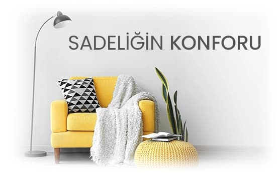 Sarı koltuk, üzerinde beyaz örgü örtü ve renkli yastık, sade dekorasyon ve rahatlık vurgulanıyor